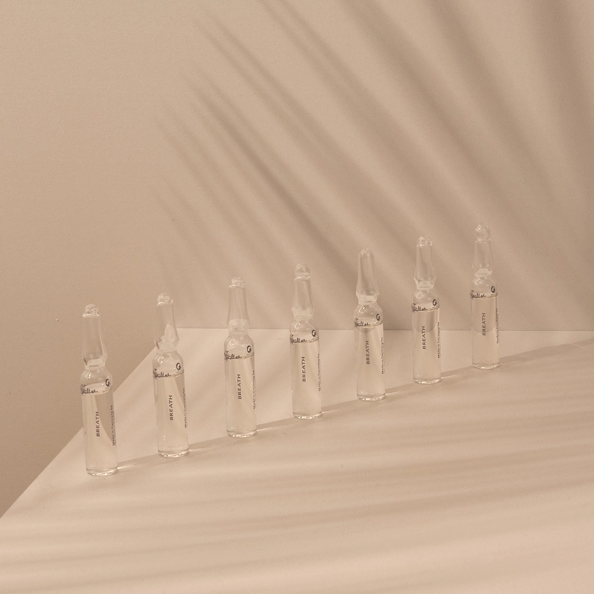 Mehrere Ampullen stehen auf einem Tisch mit rosafarbenen Hintergrund