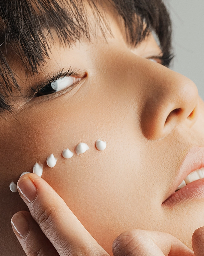 Serum is applied selectively to the woman's cheek