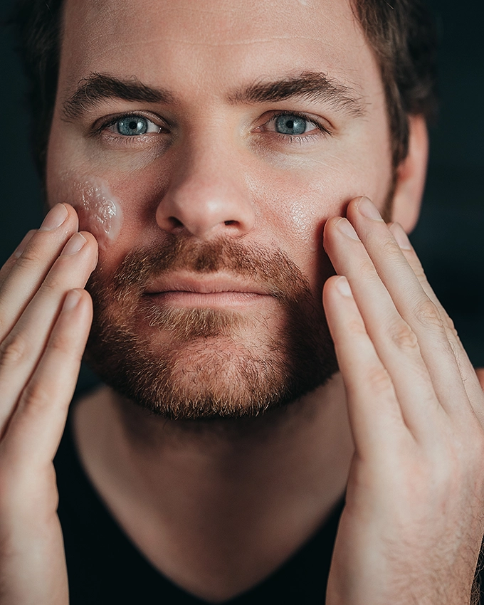 Mann trägt das Hyaluronic Power Serum auf sein Gesicht auf