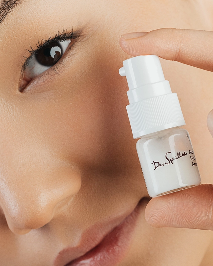 Frau hält ein Dr. Spiller Hautpflegeprodukt neben ihrem Gesicht