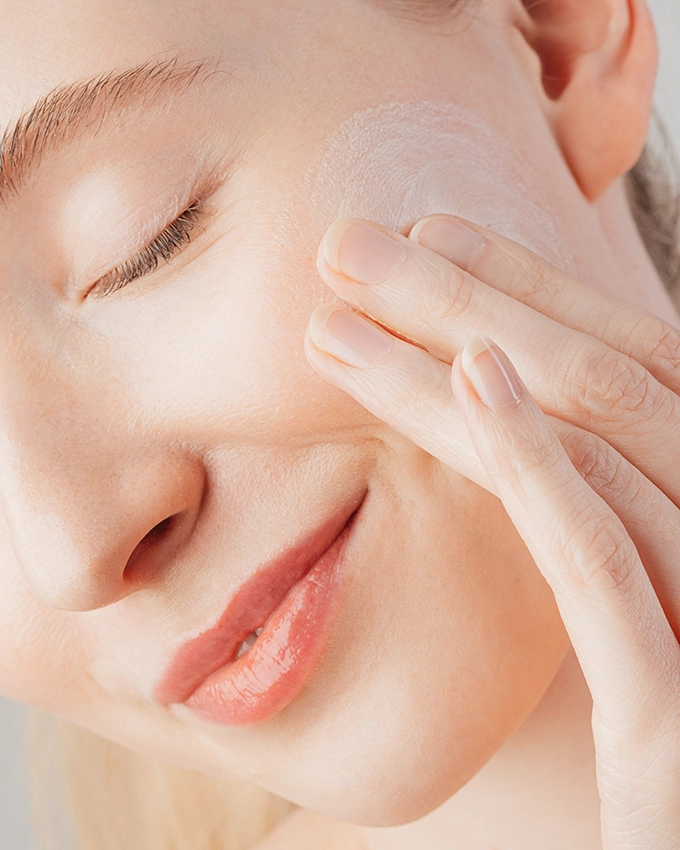 Woman exfoliates face with special exfoliating milk