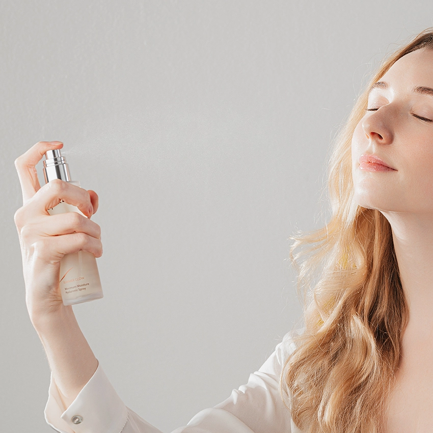Maximum Moisture Hyaluronic Spray is sprayed onto a woman's face