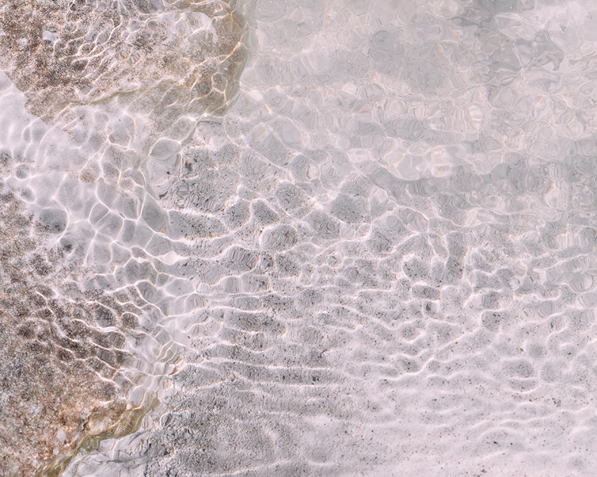 Water reflections on a sandy beach