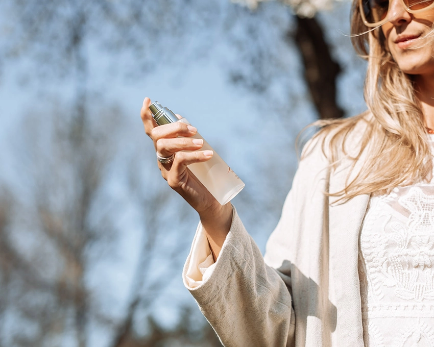 Woman with sun care spray in her hand
