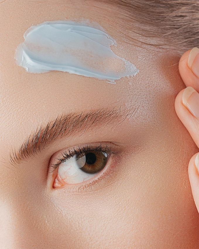 Applying face cream to the forehead