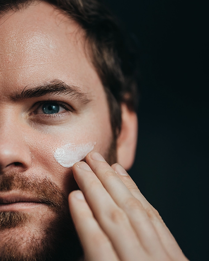 Man applies Activating Age Repair Complex to the face