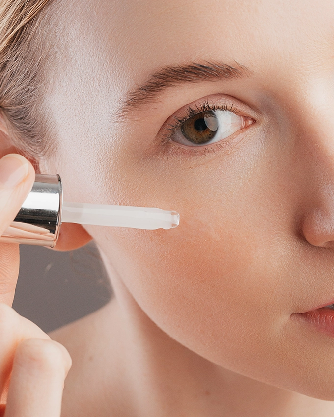 Serum is applied to the woman's cheek with a pipette