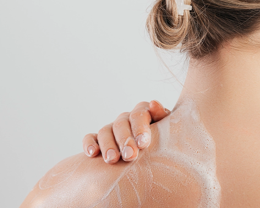 Woman applies Trawenmoor Bodywash to her neck