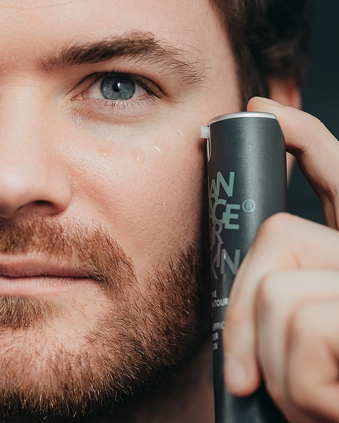 Mann wendet das Effective Eye Contour Serum an