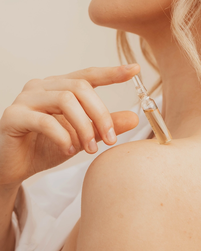 Frau hält eine Gesichtsampulle