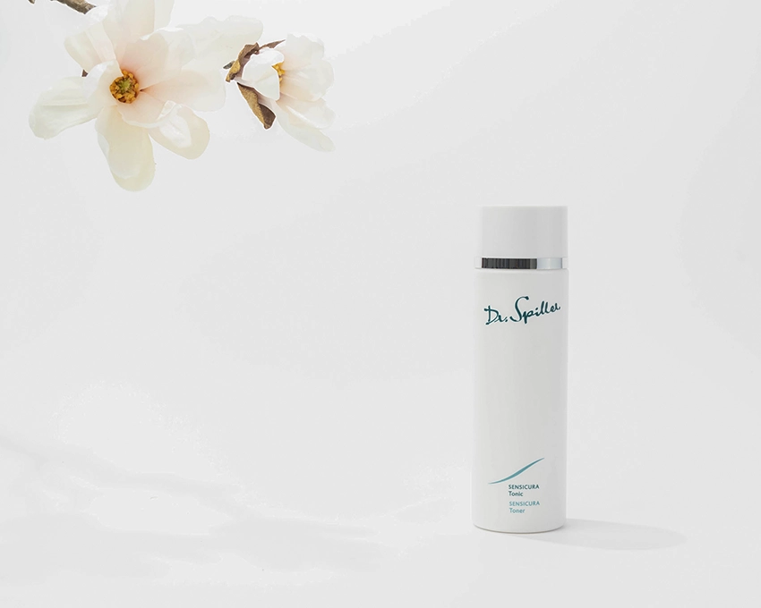 Sensicura Tonic auf weißem Hintergrund mit einer Blume